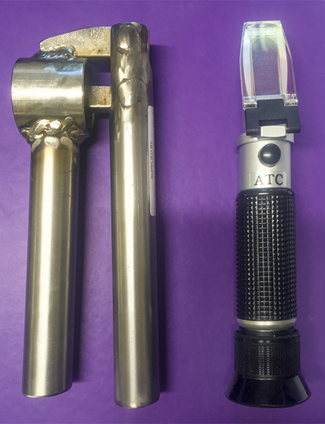 Optical Refractometer also known as a Brix Meter with garlic press for sample preparation.